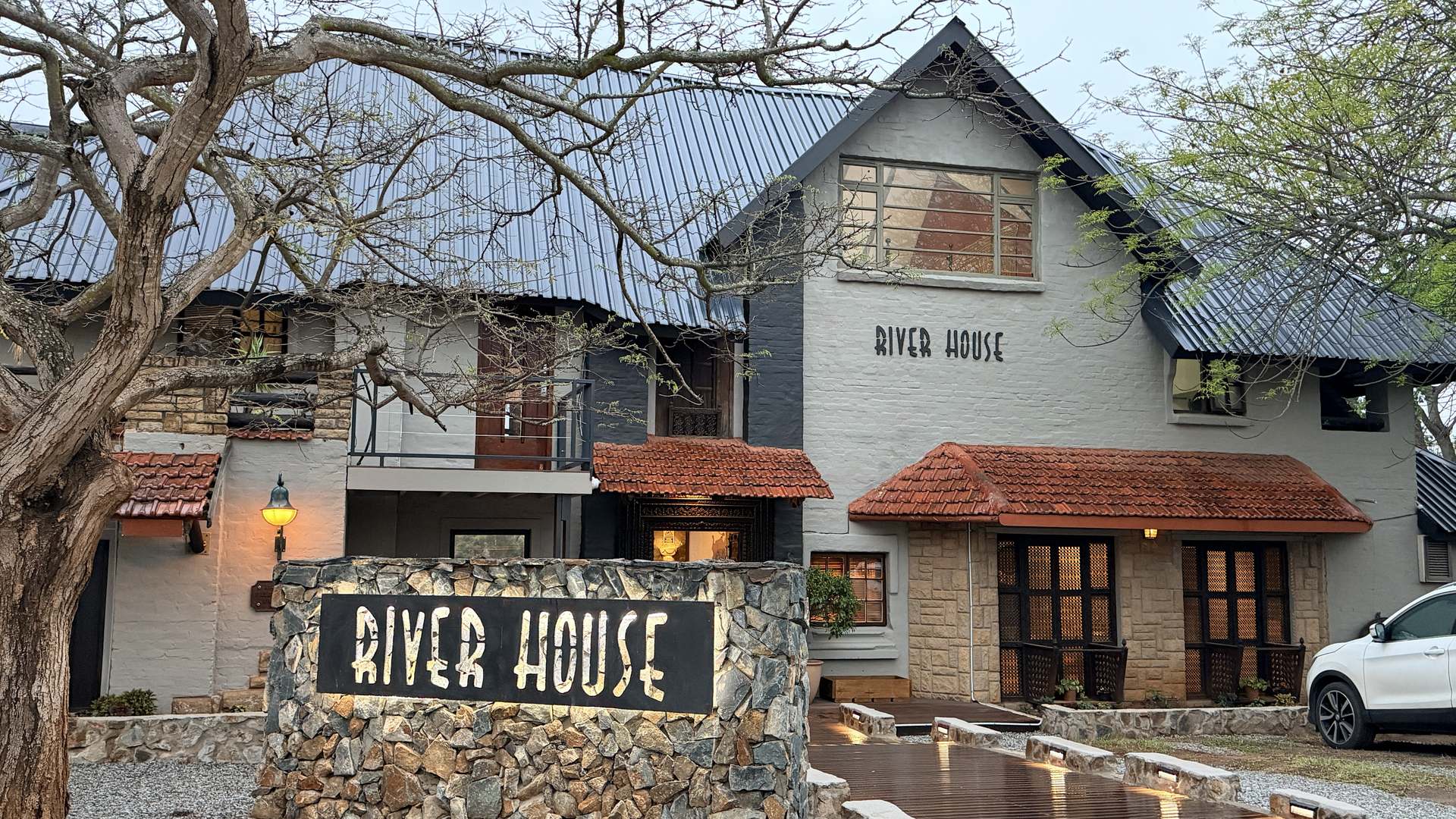 Front of River House Lodge with the stone RIVER HOUSE sign
